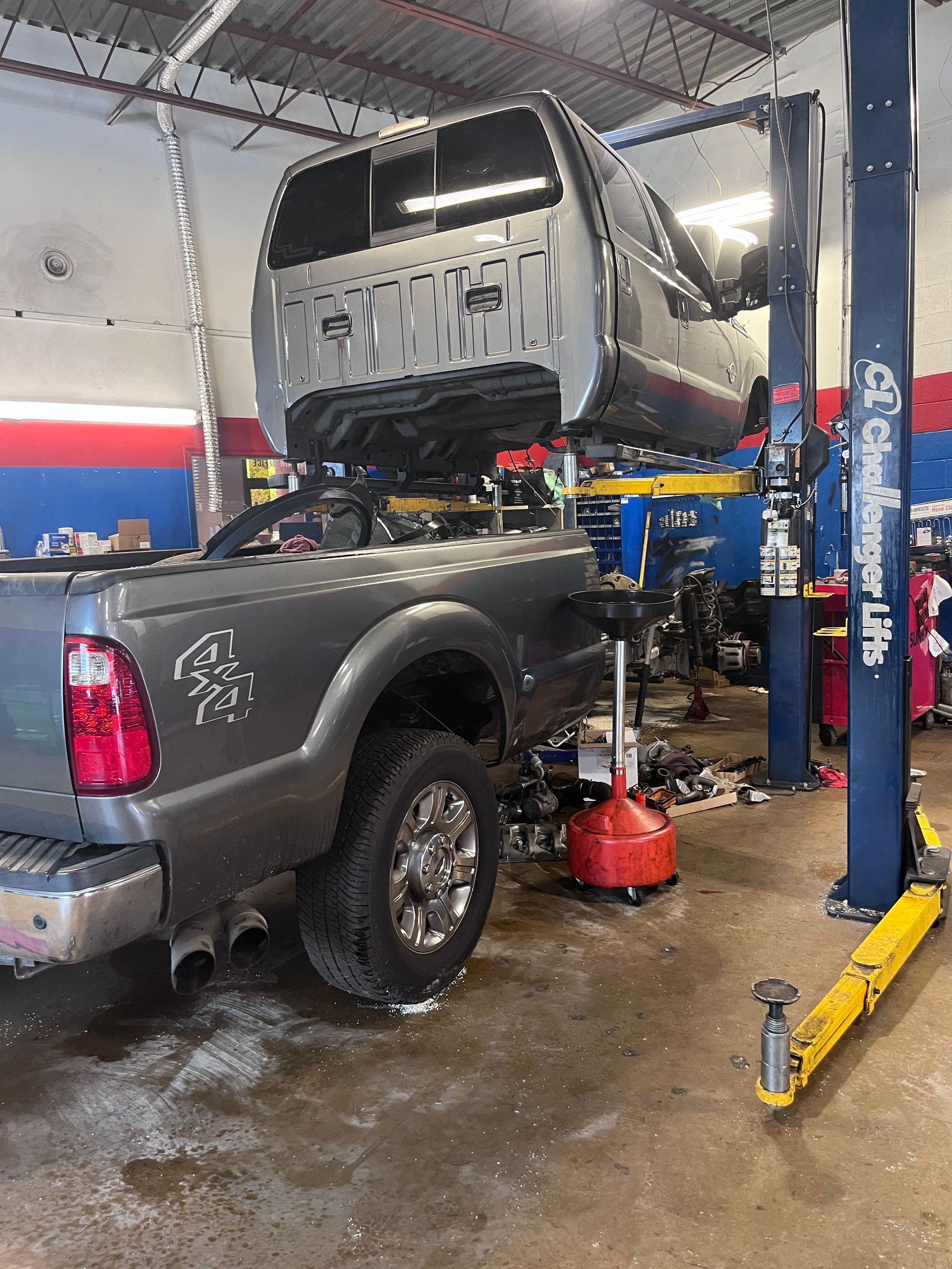 A truck is sitting on a lift in a garage.