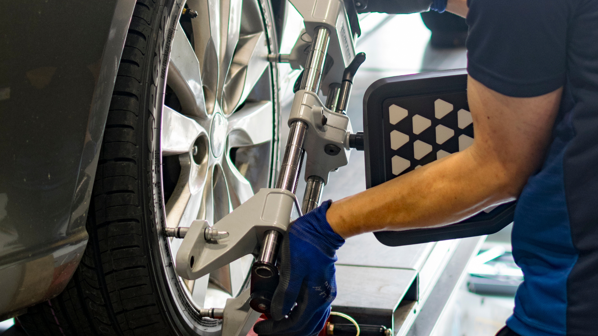 A man is working on a car wheel with a machine.