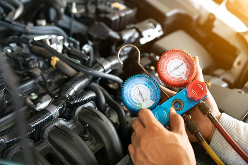 A close up of a person working on a car engine.
