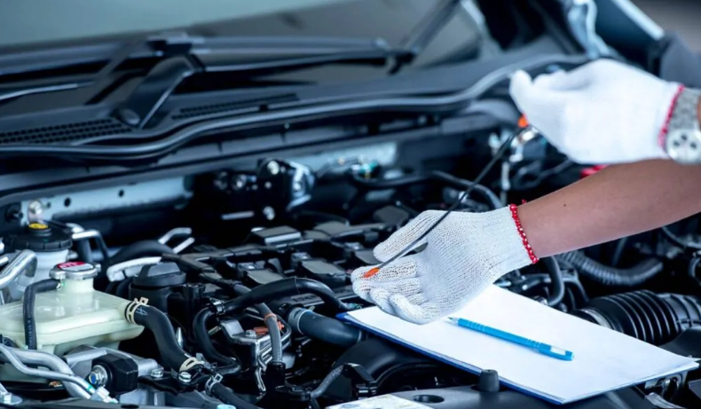 A mechanic is working on the engine of a car.