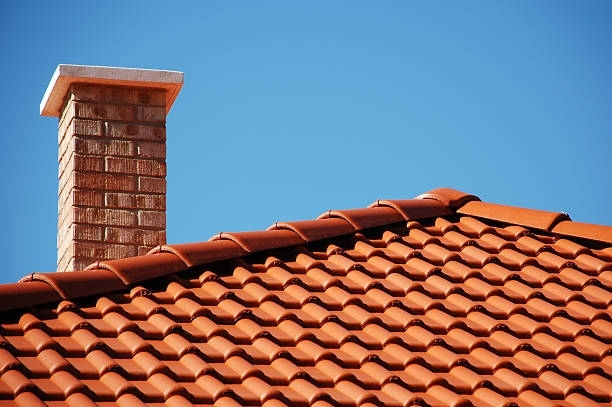 A red tile roof featuring a prominent chimney