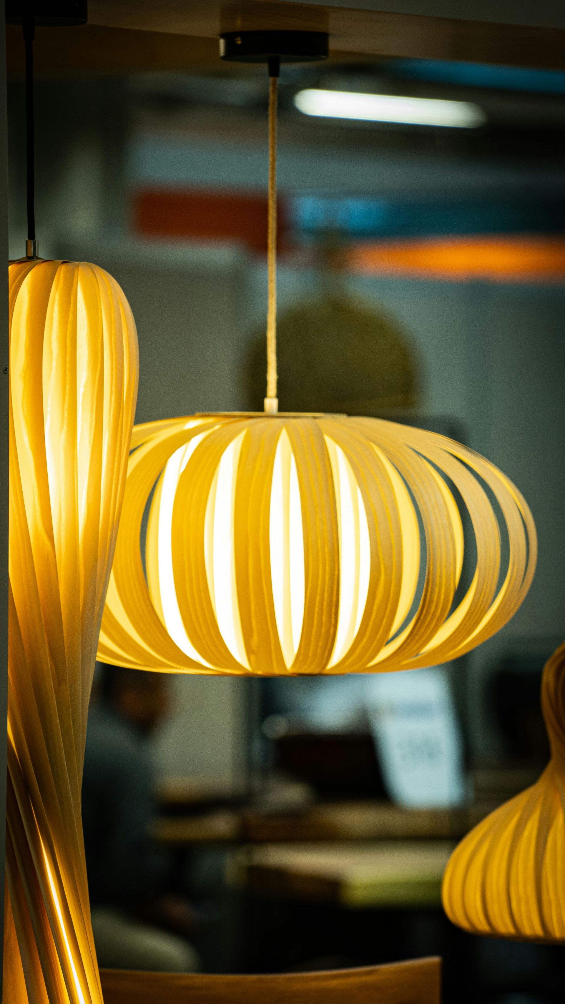 A person wearing blue gloves uses a multimeter to test a circuit breaker panel.