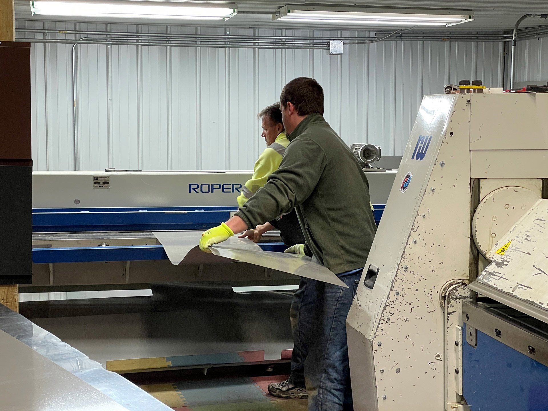 Two Worker Holding Roof Material — Hobart, WI — Mathena Roofing & Sheet Metal