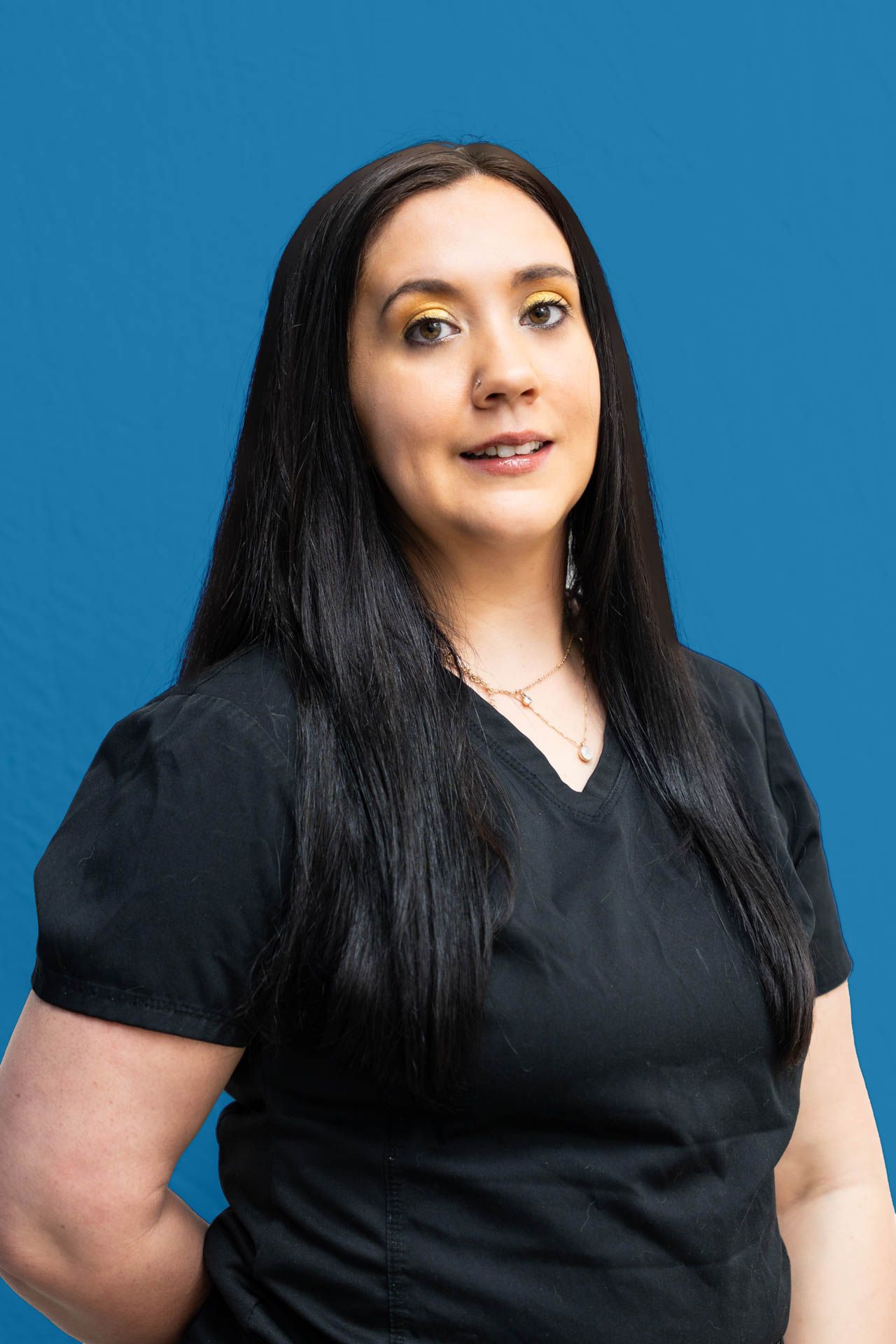 A woman in a black shirt is standing in front of a blue background.