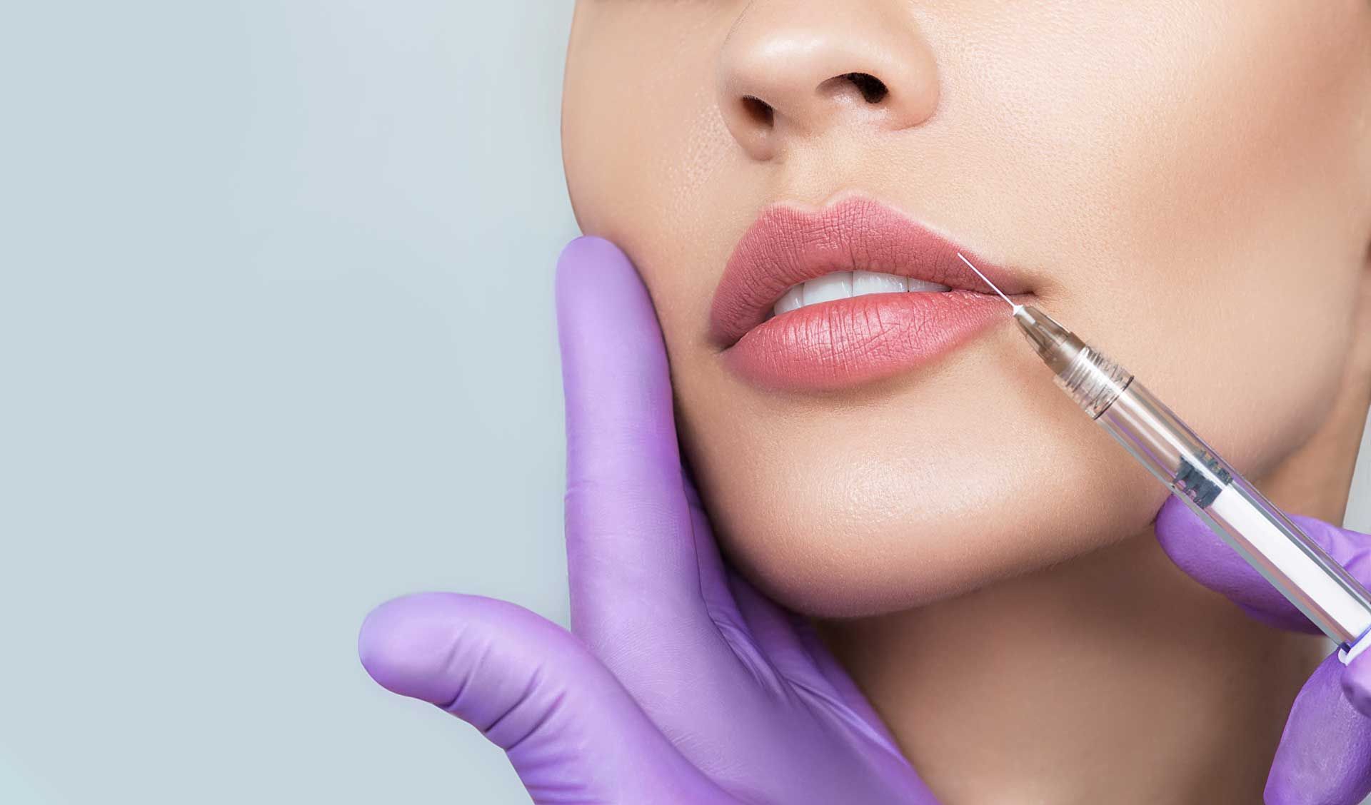 A woman is getting a botox injection in her lips.