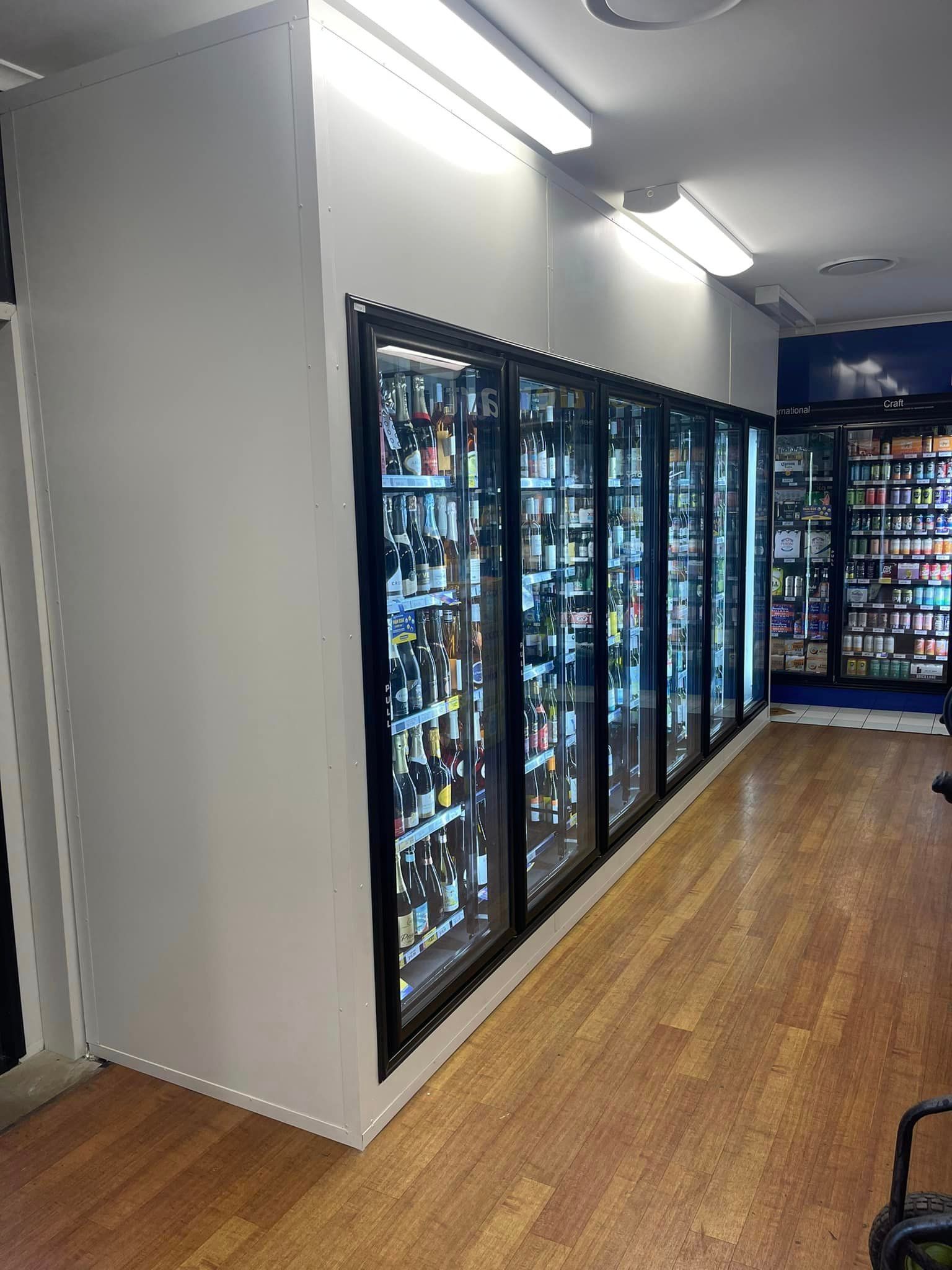 A row of refrigerators filled with lots of beer in a store — Frigid-Air PTY Ltd In South Lismore, NSW
