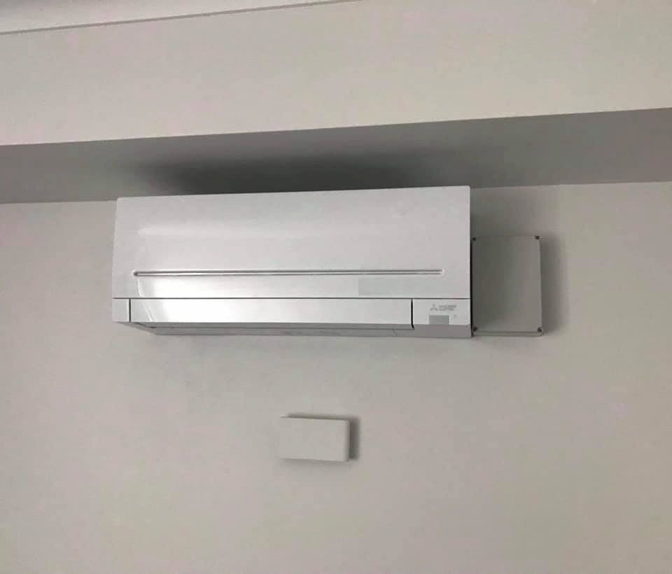 A White Air Conditioning Unit is Mounted on a Minimalist Room Wall
