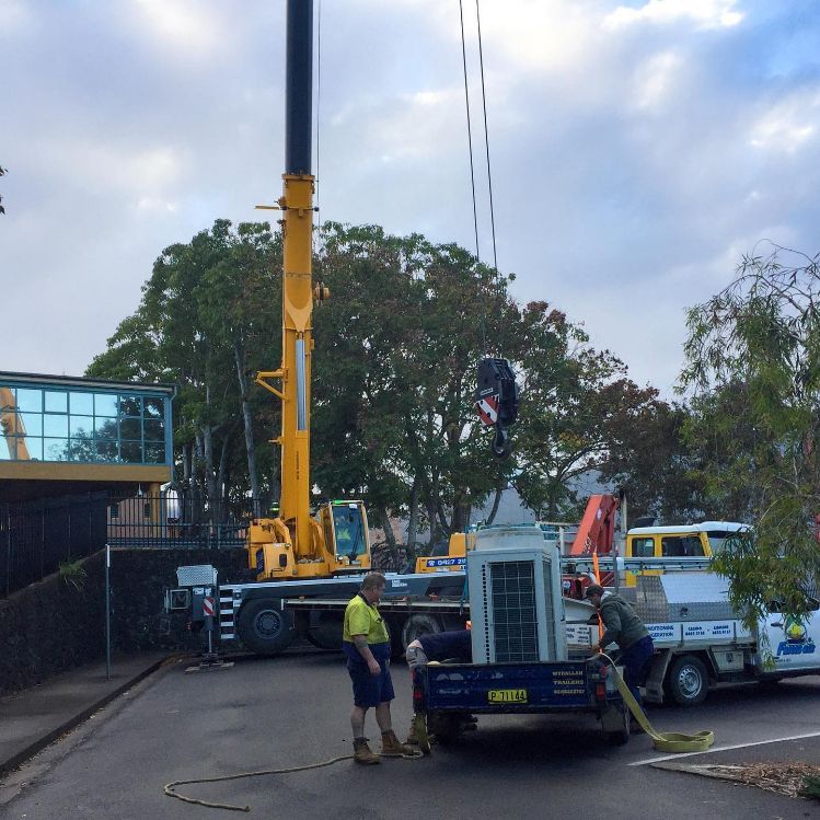 A Yellow Crane Is Being Lifted By A Truck With A License Plate — Frigid-Air PTY Ltd In South Lismore, NSW