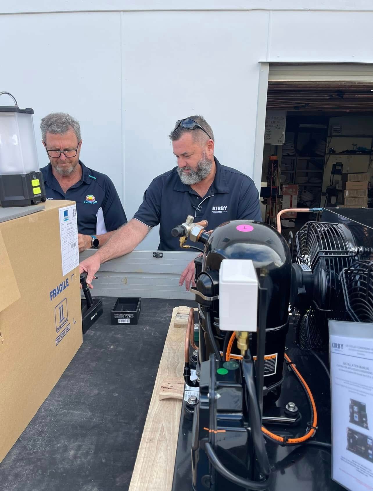 Two Men Are Working On A Machine In A Garage — Frigid-Air PTY Ltd In South Lismore, NSW
