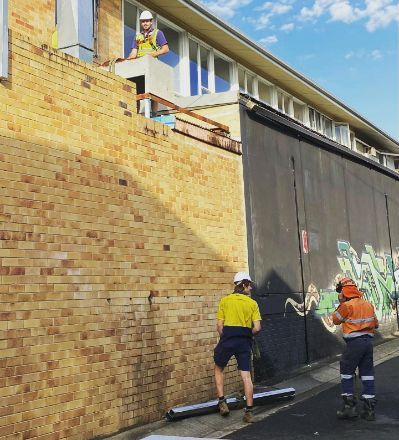 Two Construction Workers Are Working On A Brick Wall — Frigid-Air PTY Ltd In South Lismore, NSW