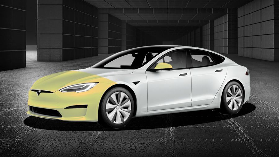 A white tesla model s is parked in a garage.