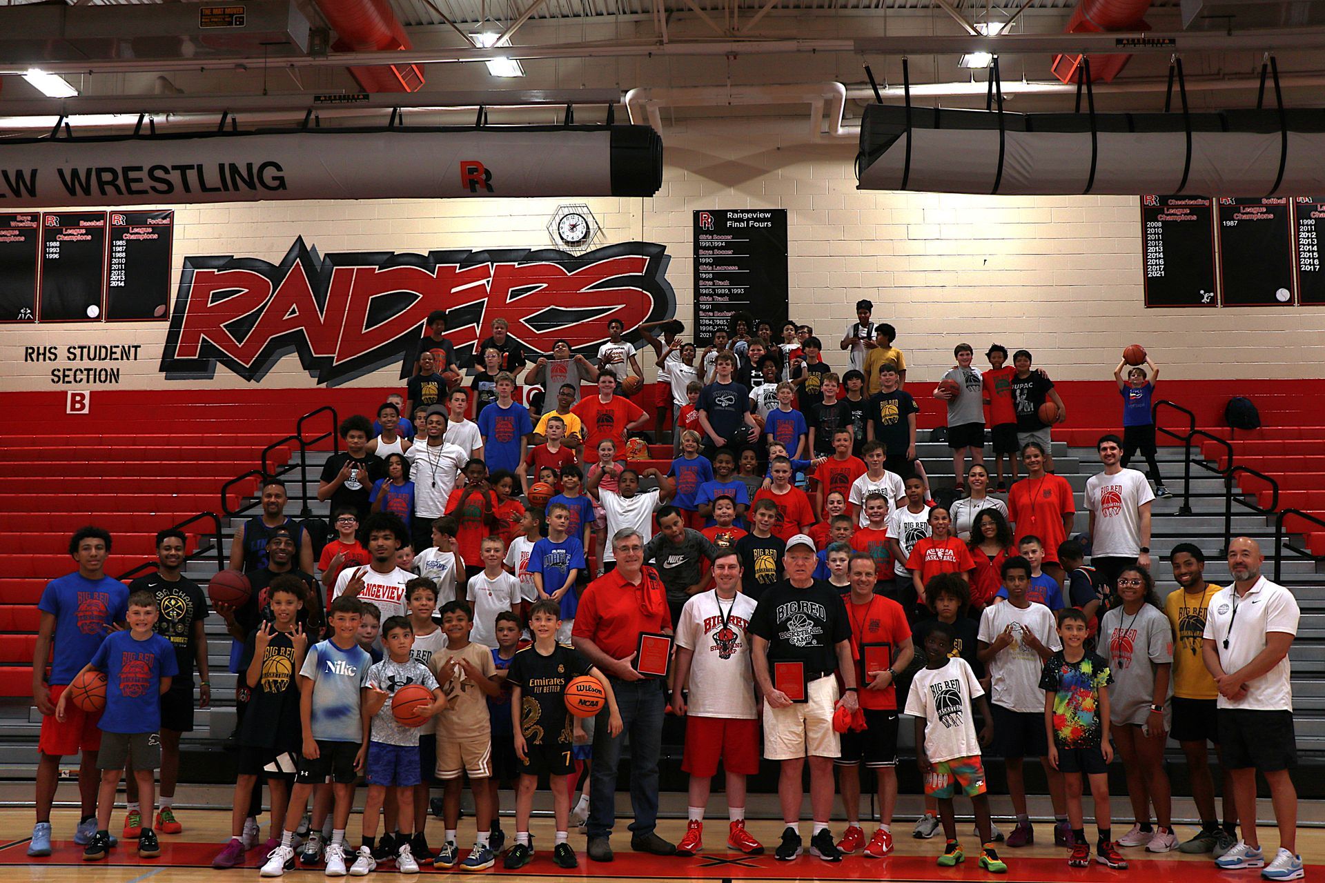 Baseball glove with ball on green grass, with blurred baseballs in the background.