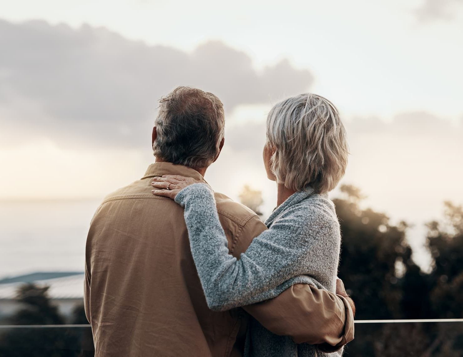 a sunset over a mountain range with a cloudy sky