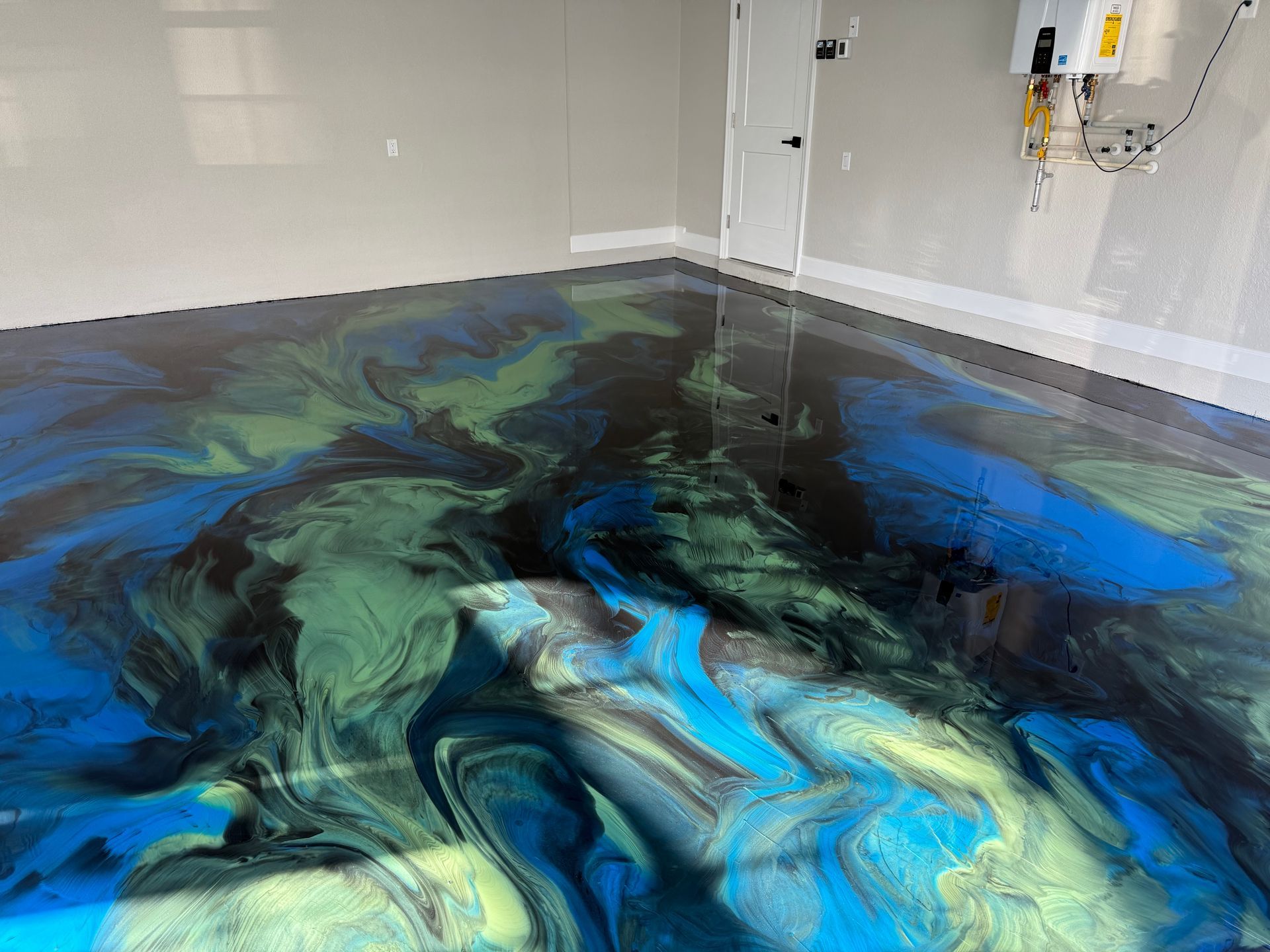 Metallic epoxy garage floor with blue, green, and black swirling colors.