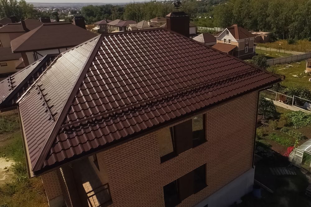 Brown-roofed Brick House With Surrounding Trees Under a Clear Sky — Callaway Roofing & Construction in Mudgee, NSW