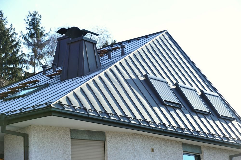 a Metal Roof With a Dark Chimney, Skylights, and a coloured Stucco — Callaway Roofing & Construction in Dubbo, NSW