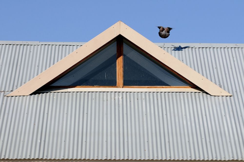 Triangular Window in a Beige Frame on a Corrugated Metal Roof — Callaway Roofing & Construction in Dubbo, NSW