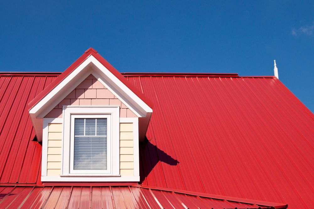 Red Metal Roof With a Dormer, Against a Clear Blue Sky — Callaway Roofing & Construction in Dubbo, NSW