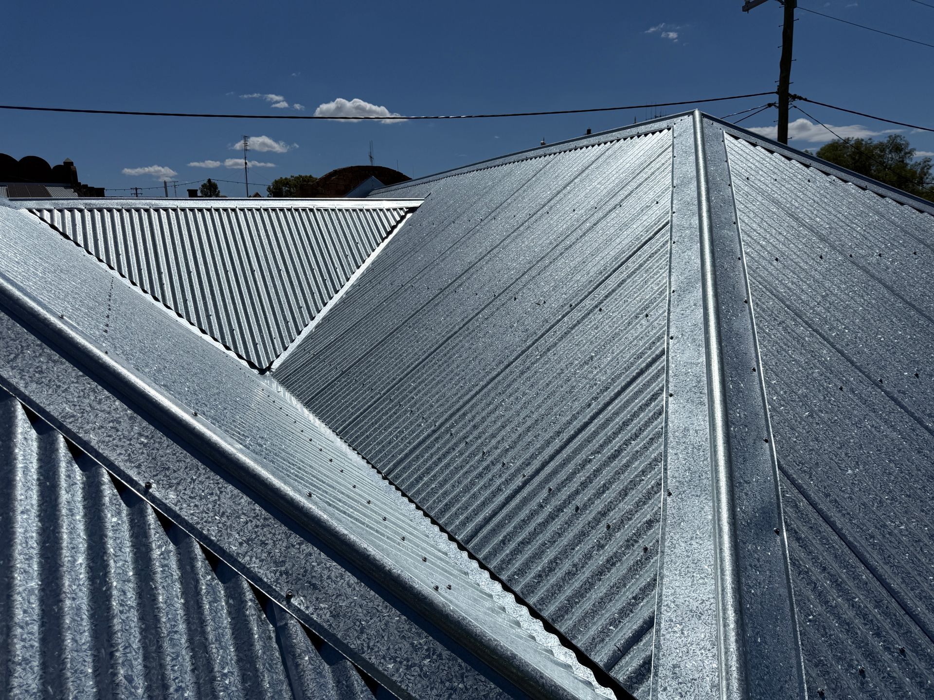 Metal corrugated roof in sunlight against a blue sky.