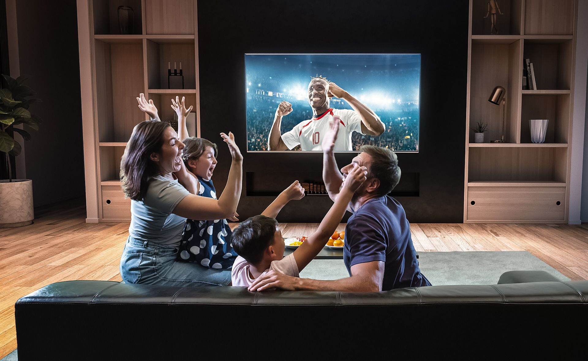 A family is watching a soccer game on a flat screen tv