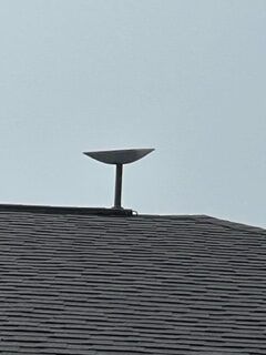 A satellite dish is sitting on top of a roof