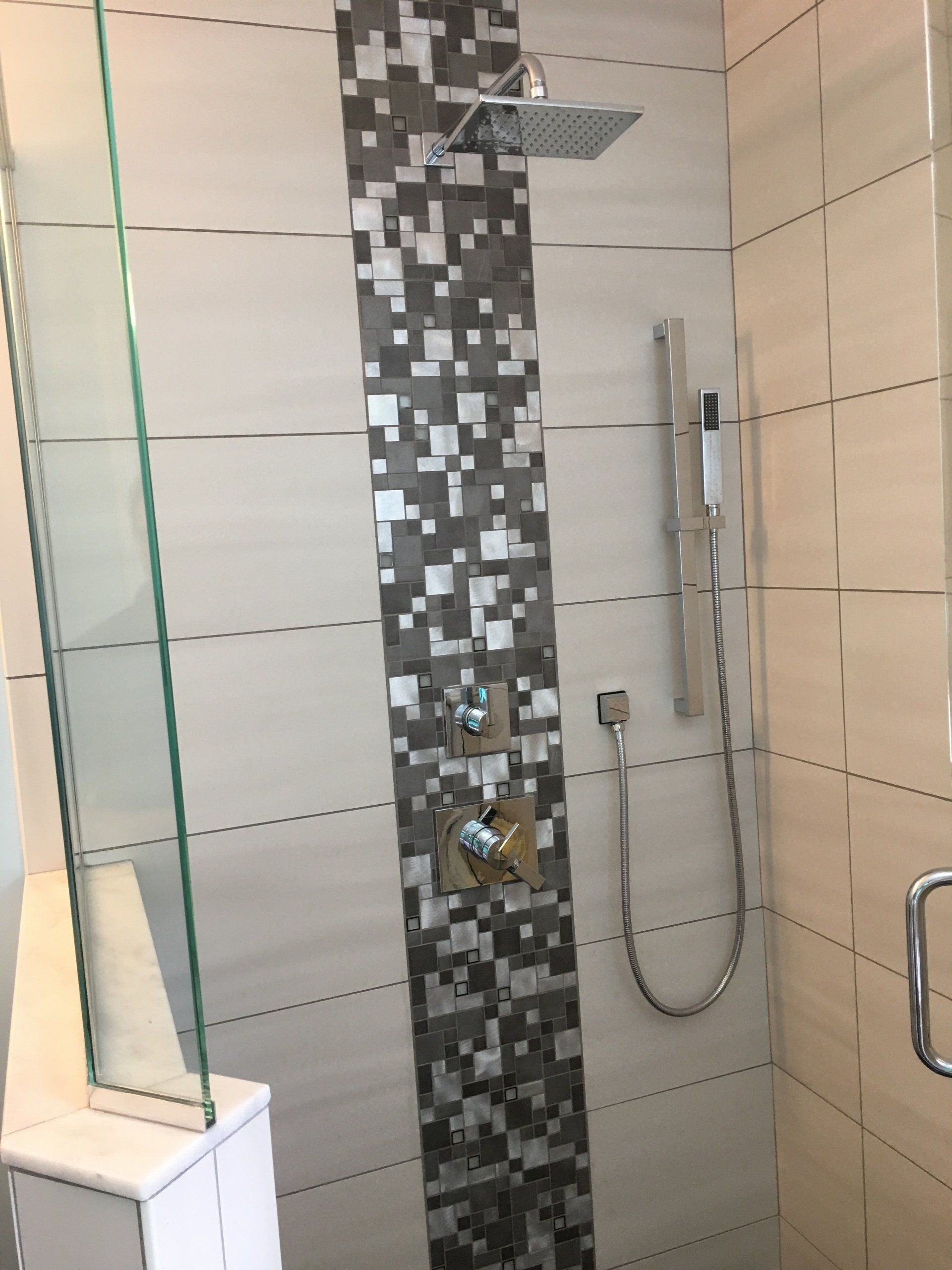 Modern shower with mosaic accent, square shower head, and hand shower.
