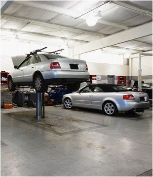 Two silver cars in a garage