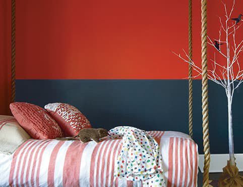 A cat is laying on a bed with a rope swing.