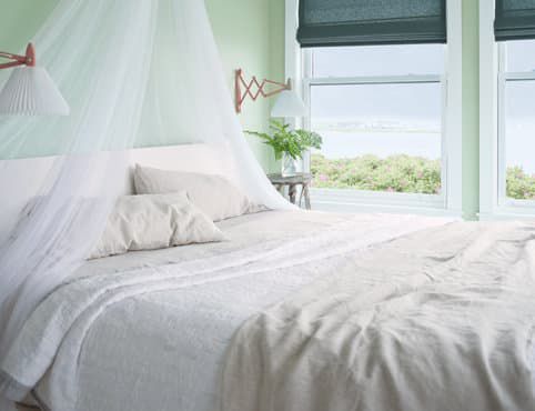 There is a bed with a canopy over it in the bedroom.