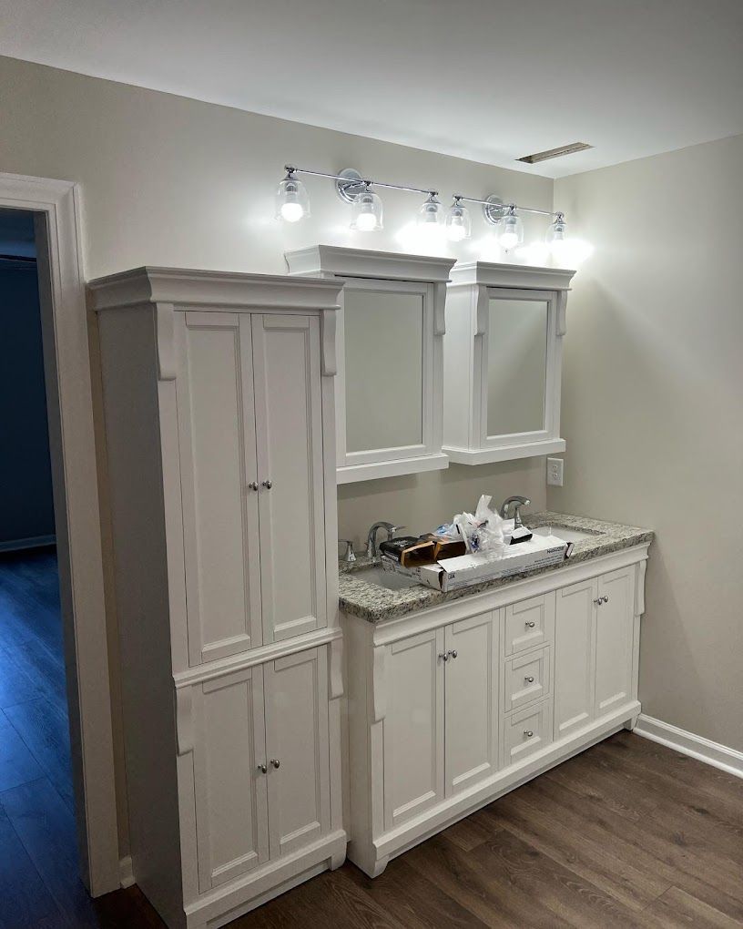 A bathroom with a sink , cabinets and mirrors.