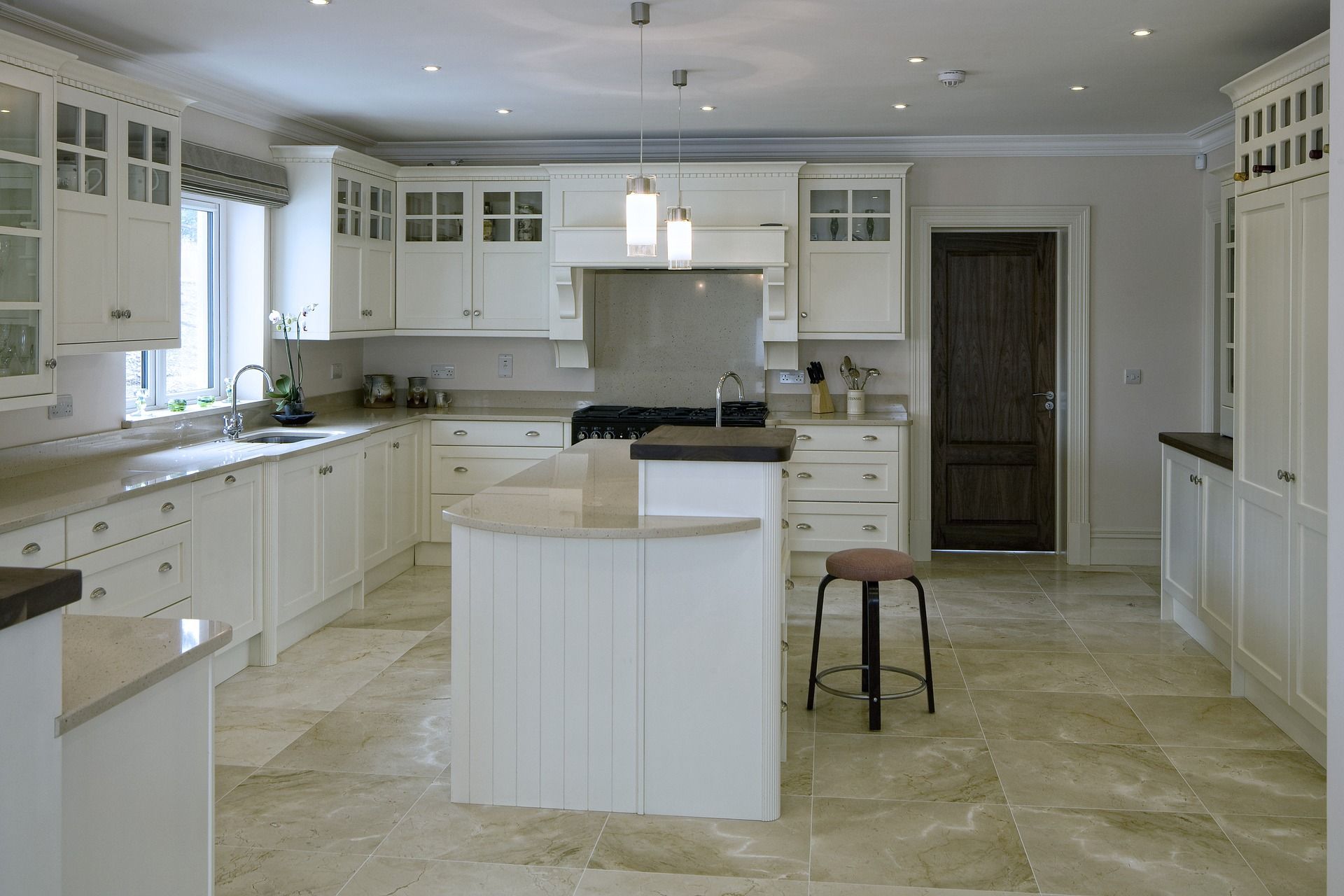 A large kitchen with white cabinets and granite counter tops