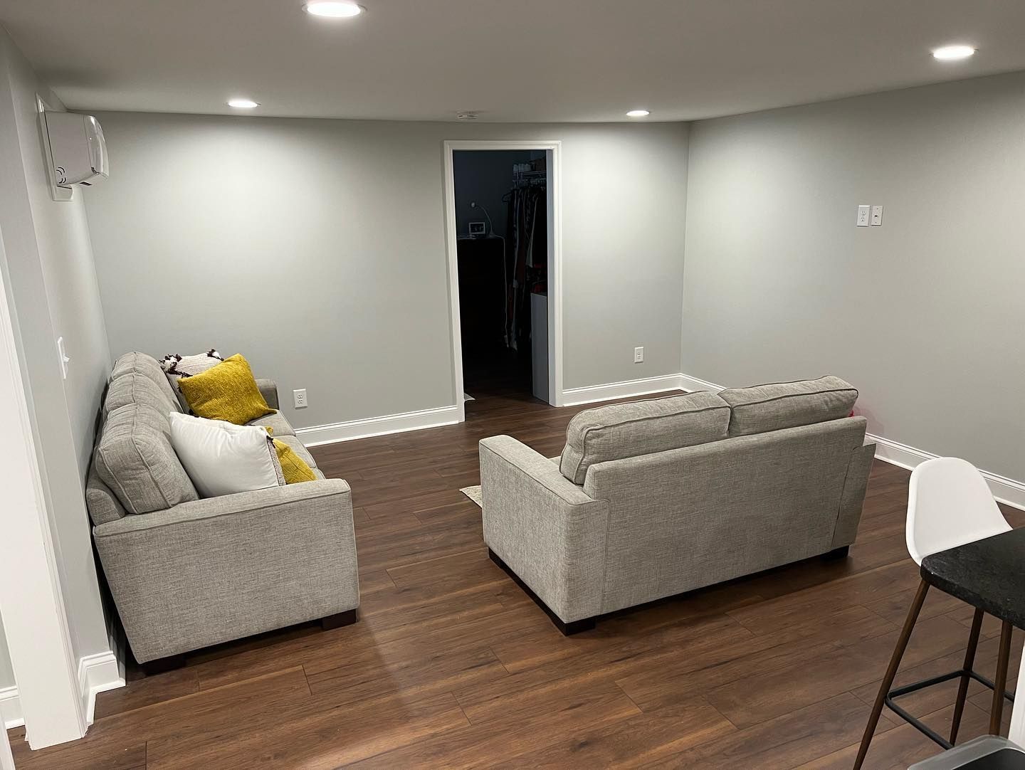 A living room with two couches and a bar stool.