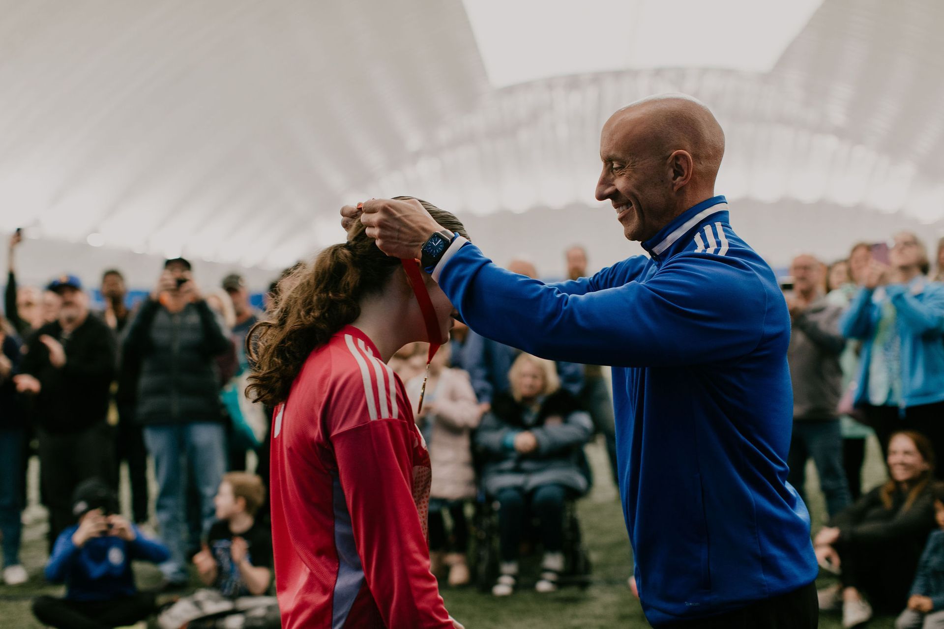 A man is putting a medal on a woman 's head.