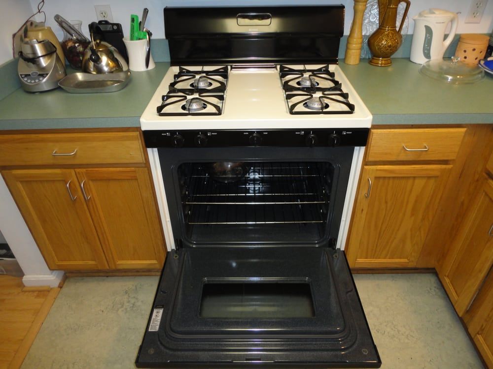 A stove with the door open in a kitchen