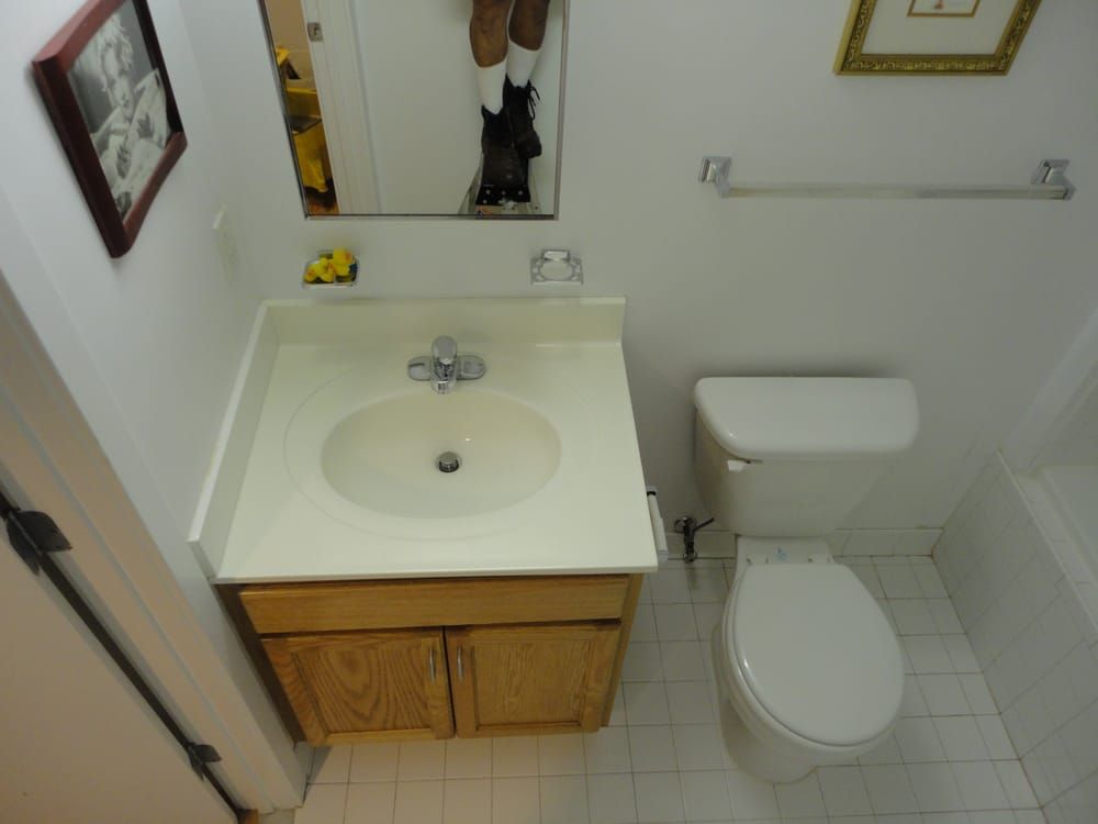 A bathroom with a toilet a sink and a mirror