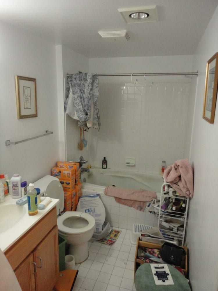 A bathroom with a toilet a sink and a tub