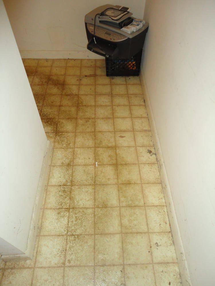 A dirty floor with a printer on it