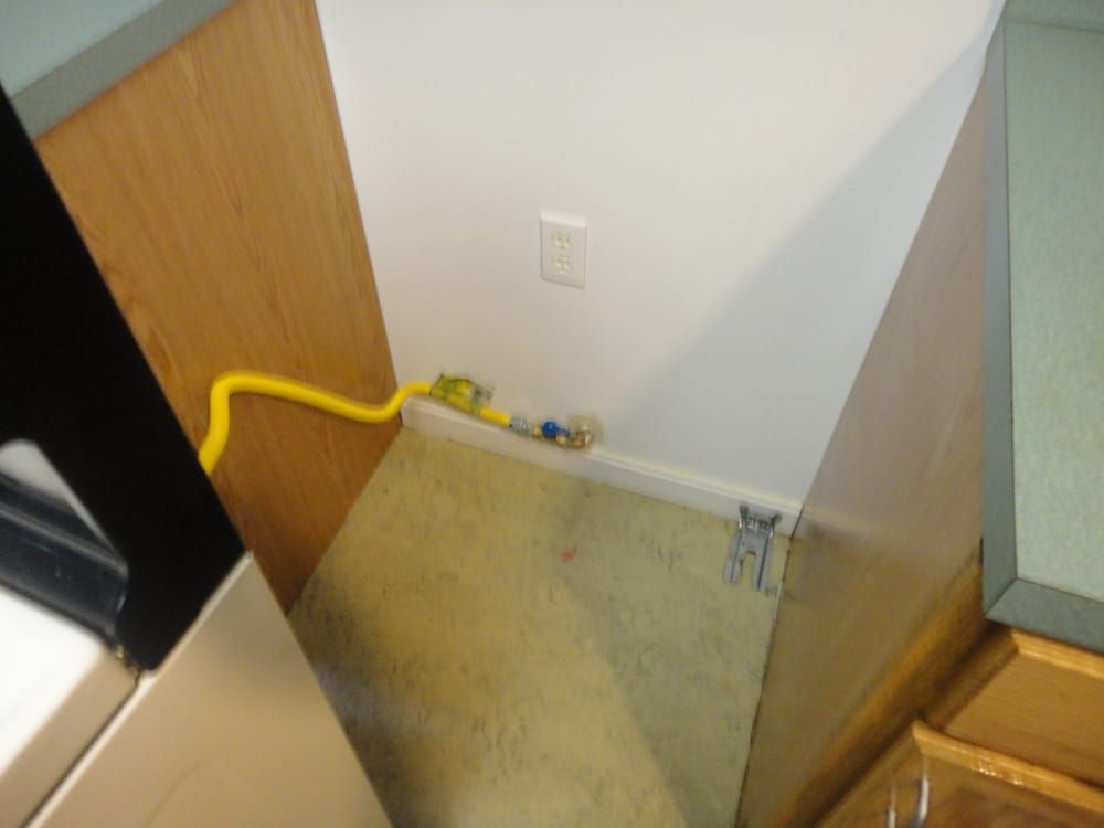 A yellow hose is attached to a wall in a kitchen