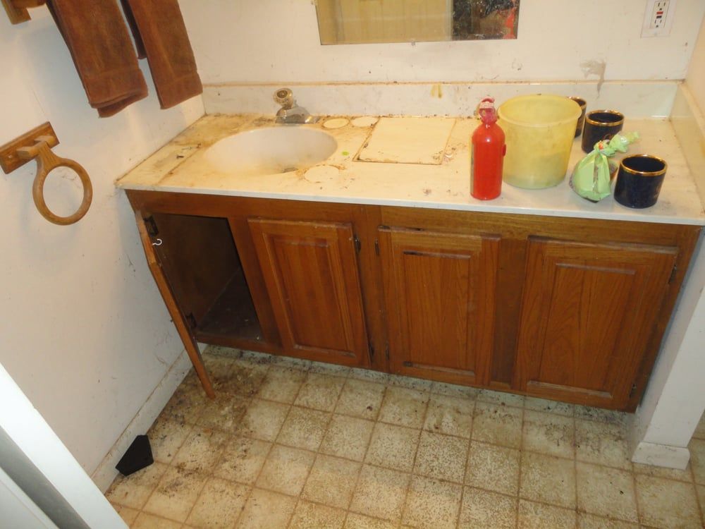 A bathroom with a sink and a bucket on the counter