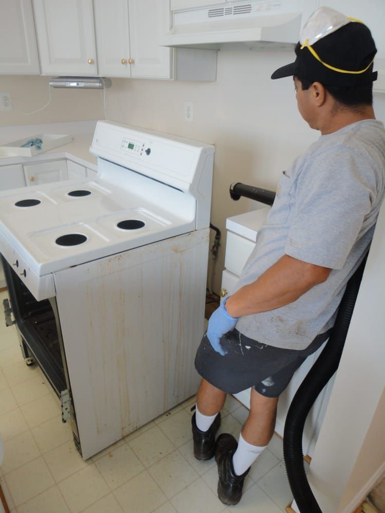 A man is sitting in front of a white stove