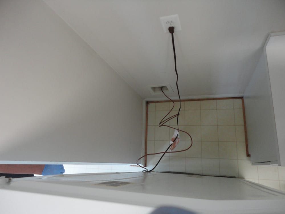 A black cord is hanging from the ceiling in a bathroom