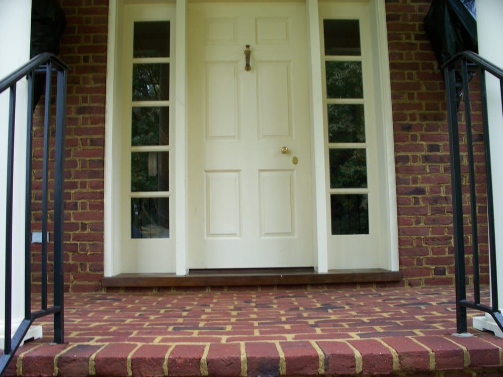 The front door of a brick house with a white door