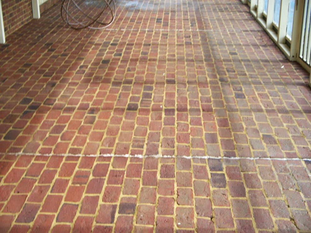 A brick walkway with a chair in the background