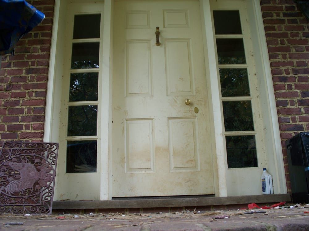 A white door with a brick wall behind it