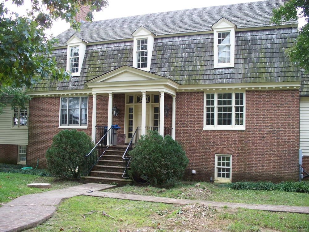A large brick house with a porch and stairs