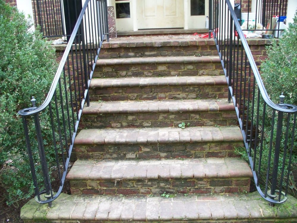 A set of stairs leading up to a house with a metal railing