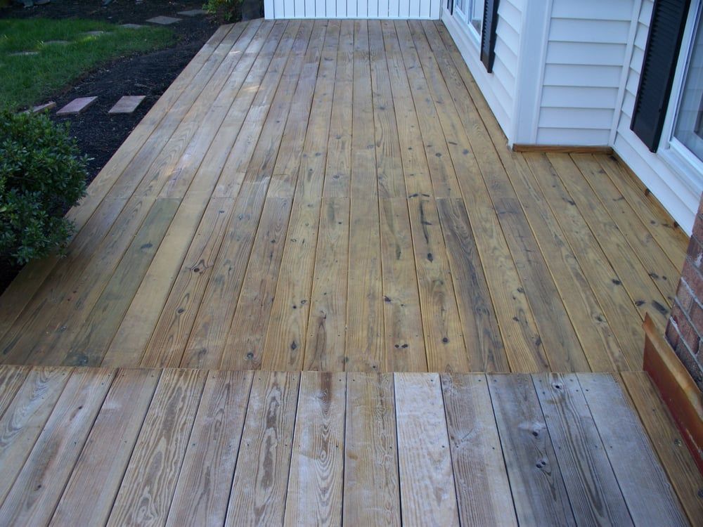 A wooden deck with a white house in the background