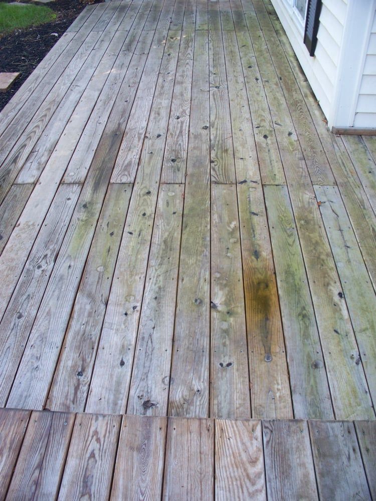A wooden deck with a white house in the background.