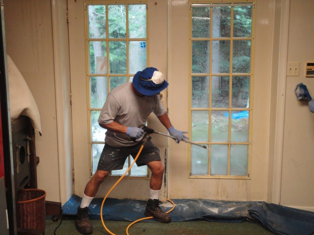 A man spraying a window with a hose