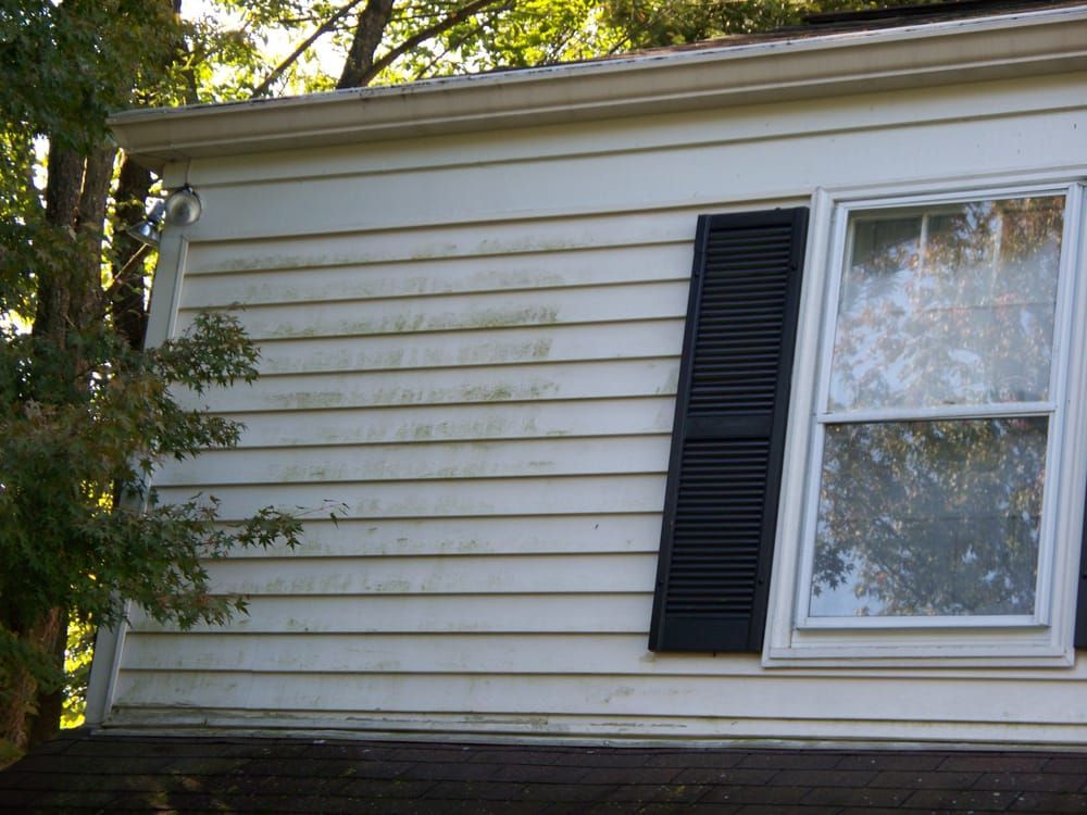 A white house with black shutters and a window